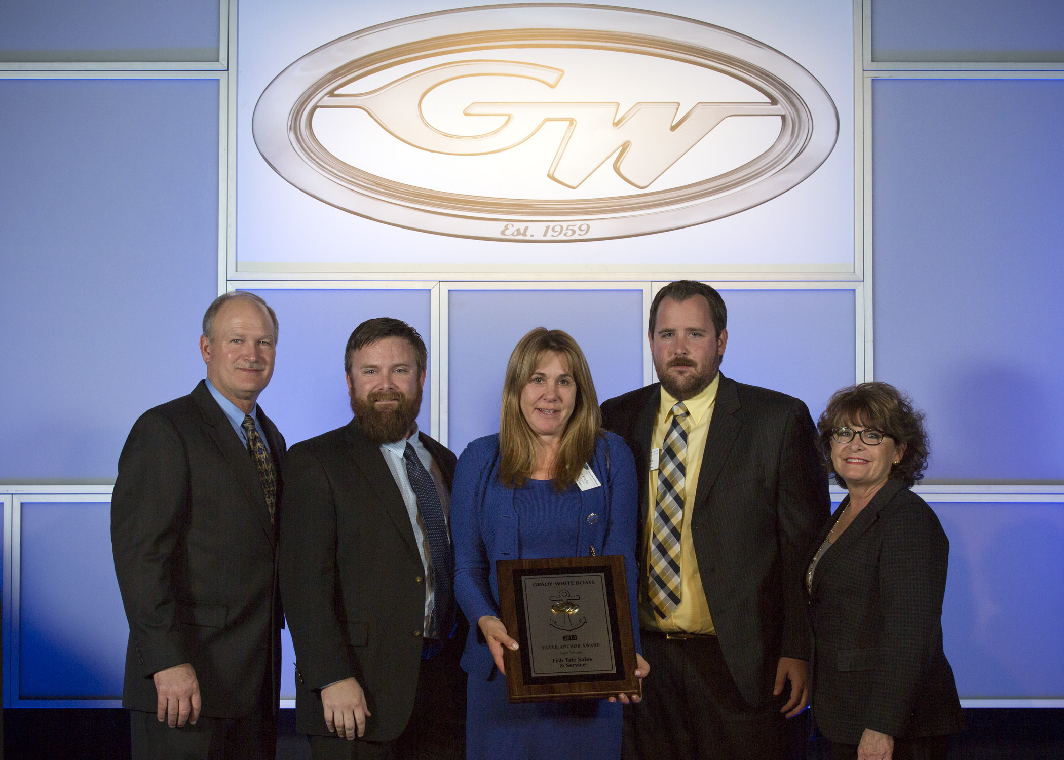 Joey Weller, vice president of sales for Grady-White Boats, left, and Kris Carroll, president of Grady-White Boats, right, present the coveted Gold Anchor Award for Outstanding Customer Satisfaction to Diane Fricke, Travis Fricke and Justin Fricke with Fish Tale Sales & Service of Fort Myers Beach. 